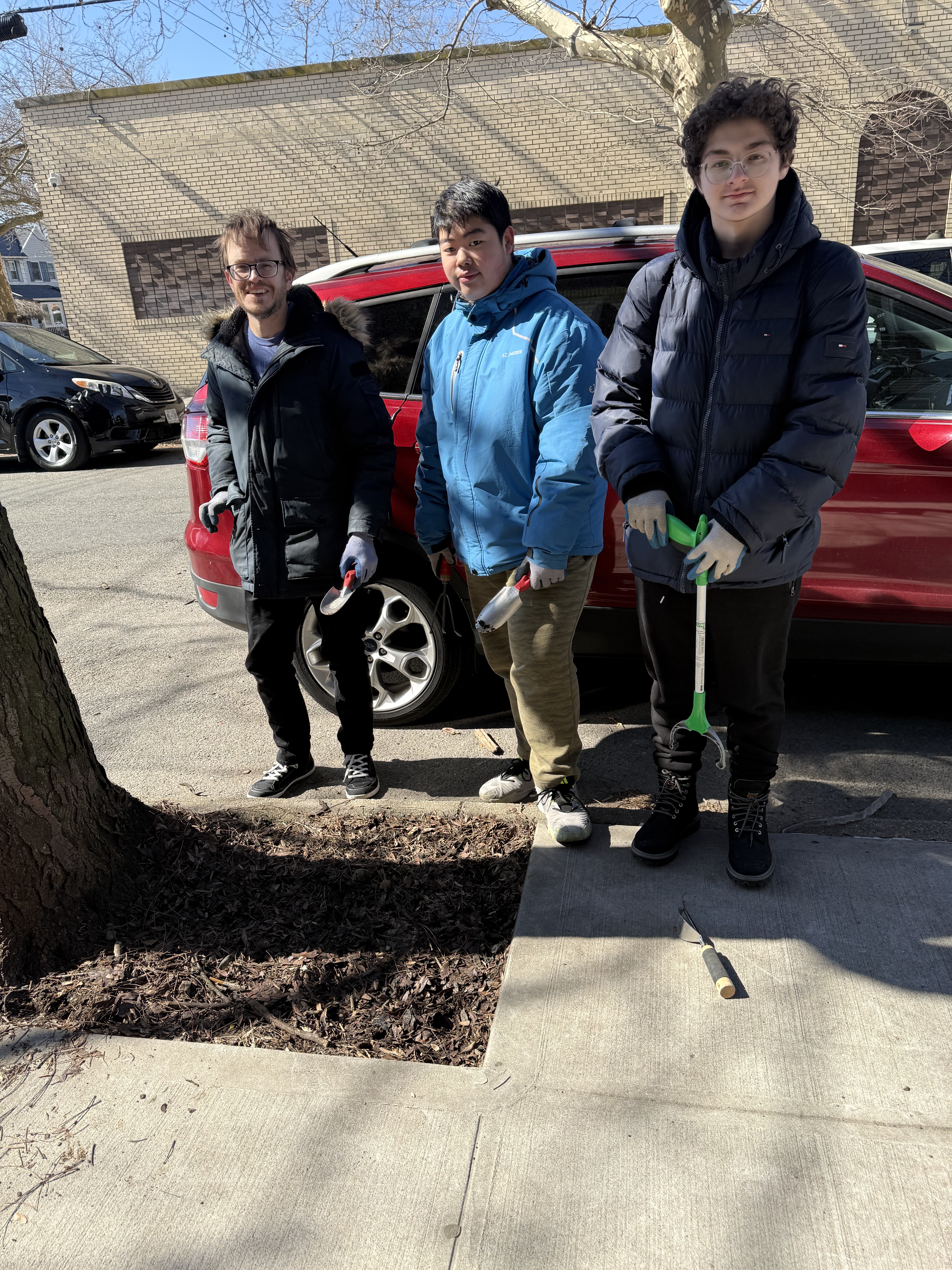 MPYAA volunteers caring for a street tree on a Marine Park sidewalk
